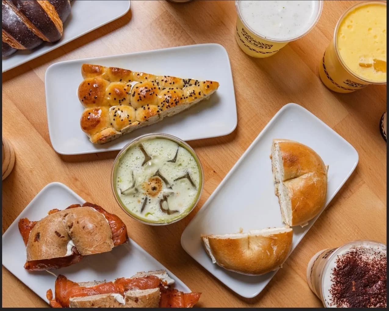 An overhead spread of Jalsah pastries, bagels, and drinks